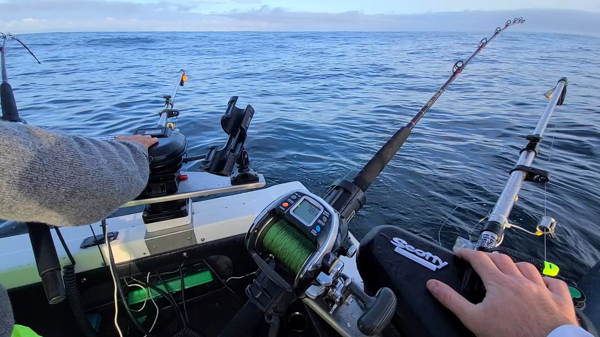 Reels of fishing rods onboard fishing boat on sunny day, with